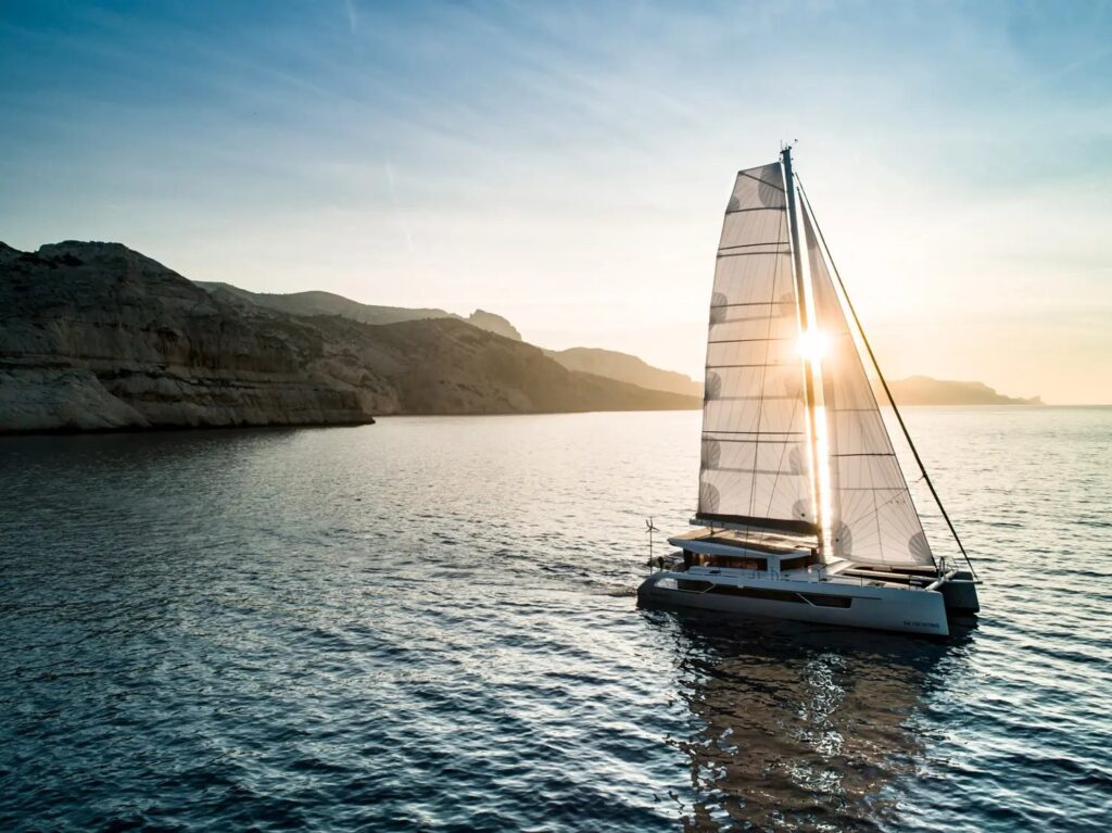 Windelo 54 sailing past cliffs at sunset